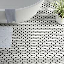 a bath tub sitting on top of a tiled floor next to a plant in a pot