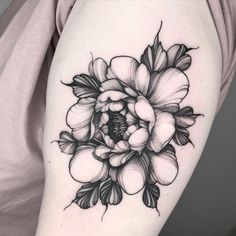 a black and white flower tattoo on the arm