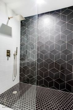 a black and white tiled bathroom with shower head