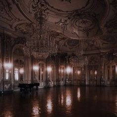 an empty ballroom with chandeliers and piano