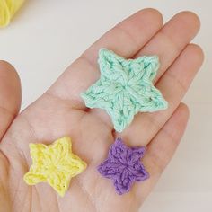 three crocheted stars are placed in the palm of someone's hand