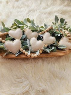 a wooden platter filled with hearts and greenery