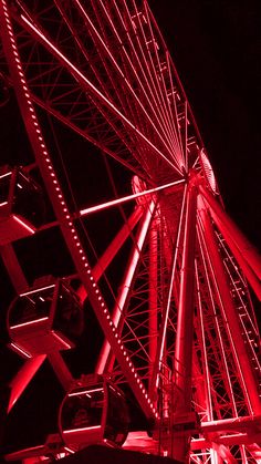 a ferris wheel lit up at night with red lights