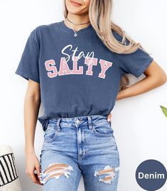 🏝️Trendy Stay Salty Summer Beach Vacation Shirt!🏝️ This Comfort Colors summer vacation graphic t-shirt has three different colored Fonts styles depending on the T-shirt color. They are listed below. It is unisex, super soft and comfortable made of 100% ring-spun ethically grown cotton. It has a relaxed fit that is made of a medium fabric that is preshrunk. Looks super cute with shirts, jeans or size up 1 to 2 sizes for an oversized beach cover up. Great gift idea for a Birthday or a Beach lover! Comes in 14 pretty colors!  🔷🔷Chambray, Washed Denim, Blue Jean, Denim, Periwinkle and Topaz Blue have Salty in the Pink letters🔷🔷 🔷🔷Blossom, Crunchberry, Chalky Mint and Island Reef have Salty in the Turquoise letters🔷🔷 🔷🔷Light Green, Seafoam, Crimson and Khaki have Salty in the Navy l Stay Salty, Summer Beach Vacation, Pink Letter, Shirt Stays, Beach Shirt, Comfort Wear, Trendy Shirts, Vacation Shirts, Beach Shirts