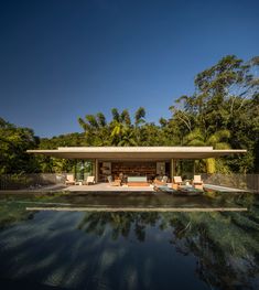 an outdoor swimming pool with lounge chairs next to it and trees in the back ground