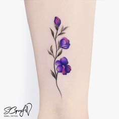 a tattoo with purple flowers on the ankle