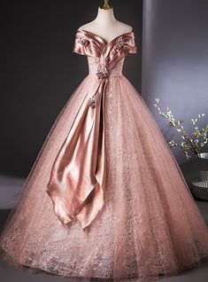 Edgy yet refined, this Quinceanera dress is for the bold and confident young woman who desires a look that is both classic and contemporary! The stunning mix of rose satin and lace creates an unforgettable gown that will leave a lasting impression. The off-the-shoulder satin neckline is gracefully adorned with floral appliques, while the satin wrap drapes elegantly down the front, adding a modern twist to the traditional ballgown style.  The skirt, made from layers of lace, is soft, romantic, and perfect for dancing the night away. The gownfitted bodice ensures a flattering silhouette, while the full skirt provides the right amount of drama and elegance. This dress is the epitome of sophistication and grace, designed to make you feel like a true princess. With simple yet elegant accessorie Quinceanera Dresses Sparkly, Debut Gowns, Kids Pageant Dresses, Birthday Cake Decorating Ideas, Quinceanera Dresses Pink, Haute Couture Gowns, Lace Ball Gowns, Quinceanera Dress, Country Wedding Dresses