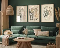 a living room with green couches and pictures on the wall above them in shades of teal