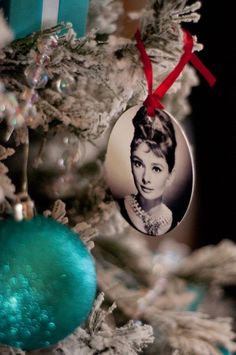 a blue ornament hanging from the side of a christmas tree