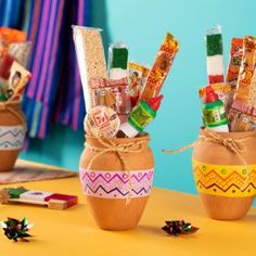 two vases with candy sticks in them sitting on a table next to other items