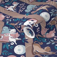 a blue and pink wallpaper with cats on it's back ground next to a roll of wrapping paper