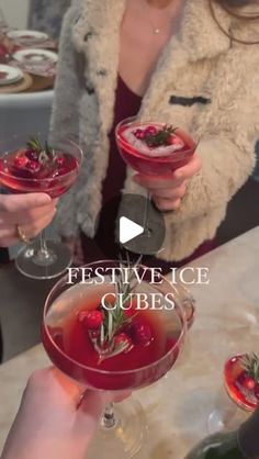 two women holding up wine glasses with strawberries in them and the words festive ice cubes