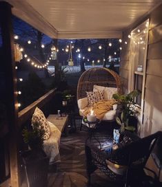 the porch is decorated with lights and wicker furniture