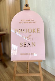 a welcome sign for the bride and groom to arrive at their wedding ceremony in pink