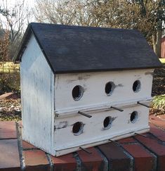 a white birdhouse with holes in the roof