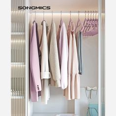 an open closet with clothes hanging on hooks and other items in the room, including sweaters