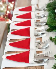 a long table with silverware and santa hats on it