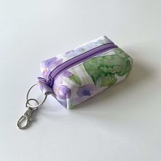 Floral fabric mini keychain pouch, keyring coin purse, earphone case, airpod case, earbud pouch, lipstick pouch   Handmade in the UK Size:  - approximately 8cm (L) x 5cm (H) with 2.5cm base Material:  - 100% cotton (both outer and inner layer) - YKK zipper closure Notes:  - The position of pattern prints may slightly vary due to the different batches of the fabric - The actual color may slightly vary due to lighting effects and monitor settings Rectangular Travel Coin Purse With Keychain, Earbud Pouch Pattern, Earphone Pouch Diy, Purple Pouch Coin Purse For Everyday Use, Purple Pouch Coin Purse For Daily Use, Lipstick Pouch, Earbud Pouch, Earphone Pouch, Keychain Pouch