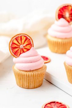 cupcakes with pink frosting and grapefruit on top