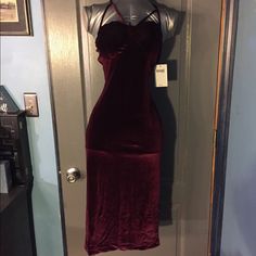 a red velvet dress hanging on a door