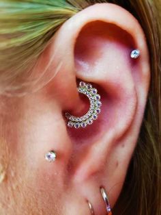 a woman with two piercings on her ear and one has a crescent shaped ring