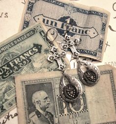 One of a kind Victorian button earrings from Beautiful Ruin.  Created from a matching pair of Victorian luster buttons (silver wash on black glass), circa 1880-1900, that have been mounted on textured silver drops.  Paired with silver filigree crosses, they hang 2.75" from silvertoned leverbacks. Vintage Teardrop Nickel Free Plug Earrings, Handmade Vintage Teardrop Plug Earrings, Silver Vintage Charm Earrings For Gift, Silver Earrings With Vintage Charm As Gift, Silver Earrings With Vintage Charm For Gift, Victorian Plug Earrings As Gift, Vintage Plug Earrings For Gift, Ornate Vintage Charm Earrings For Gift, Ornate Vintage Charm Earrings As Gift