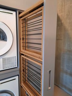 a washer and dryer in a room with wooden shelves next to each other