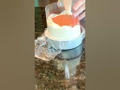 someone is decorating a cake with orange icing