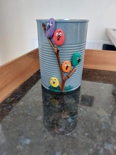 a can with some buttons on it sitting on a counter top next to a plant