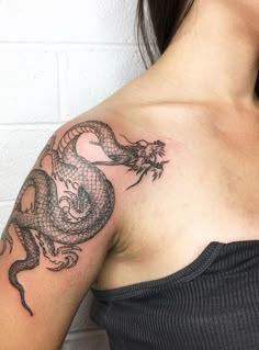 a woman with a dragon tattoo on her shoulder