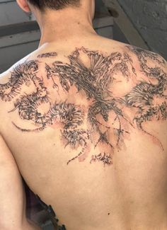 the back of a man's neck with an intricate tattoo design on his chest