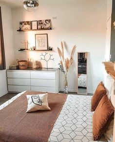 a bed room with a neatly made bed and some pictures on the wall above it