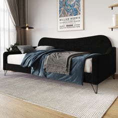 a black couch sitting on top of a wooden floor next to a white rug in a living room