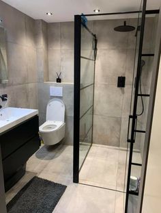 a bathroom with a toilet, sink and shower stall in the middle of the room