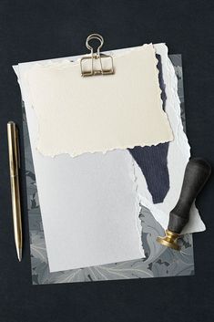 a piece of torn paper with a clipboard attached to it next to a pen