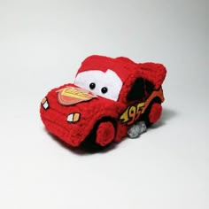 a small red toy car on a white surface