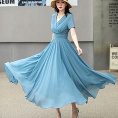 a woman wearing a blue dress and hat