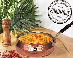 a pot filled with food sitting on top of a wooden table next to a plant