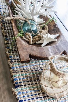 a wooden table topped with vases filled with sea shells and starfish on top of it