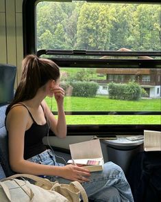 a woman sitting on a train looking out the window with her head in her hands