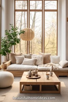 a living room filled with lots of furniture next to a large window and potted plant