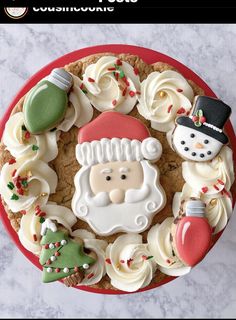 a christmas cookie decorated with icing and frosting on top of a red plate