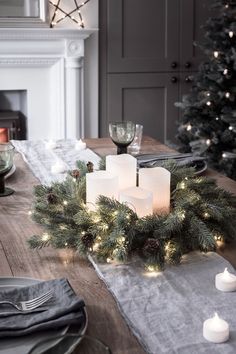 a table set with candles, plates and napkins for christmas dinner or other special occasion