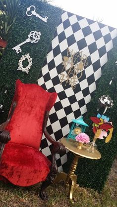 a red chair sitting next to a black and white wall with lots of keys on it