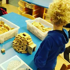 a boy looking at some wooden blocks on a table