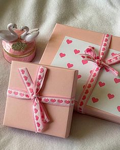 two wrapped gifts with pink hearts on them