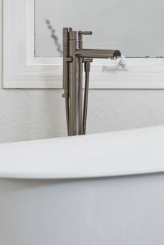 a white bath tub sitting next to a mirror