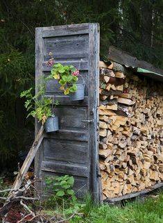 a pile of firewood sitting next to a wooden shed