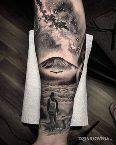 a man's arm with an image of two people and a mountain in the background