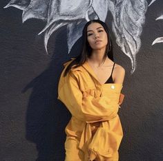 a woman standing in front of a graffiti wall